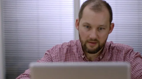 Male office worker solving a problem at his desk, modern office background. Stock-Footage 73123921