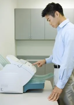 Male office worker using fax machine Stock Photos
