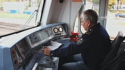 Male old train driver at the control panel in cockpit cab of electric speed Stock Footage 254531687