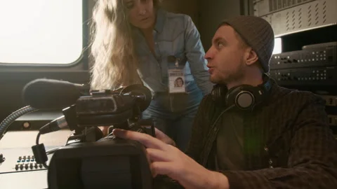 Male Operator Explaining Video Camera Functions to Female Reporter in TV Truck Video stock 300401042