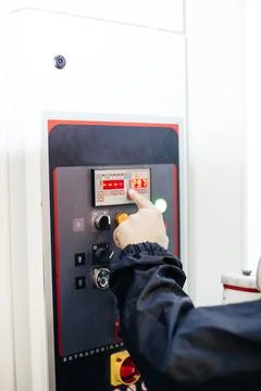 Male operator in front of machine operating console in factory. Stock Photos