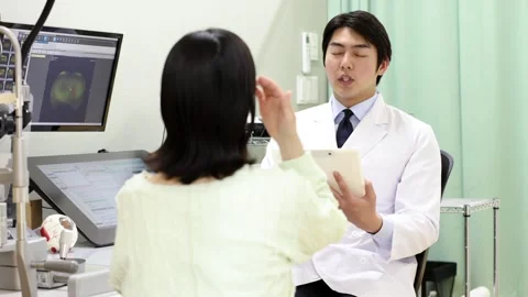 Male Ophthalmologist Explaining Eye Test Results to Female Patient Stock-Footage 344238423