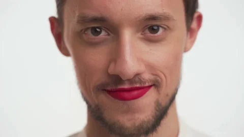 Male with painted lips looking at camera, flirting, shy on white background Stock Footage 147571690
