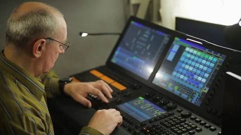 A male painter at the remote control programs the stage light for the show 库存影片 127422595