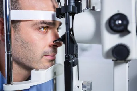 Male patient getting his cornea checked with slit lamp Stock Photos