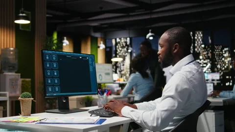 Male PC user interacting with AI chat system on computer at office after hours Stock Footage 318565674