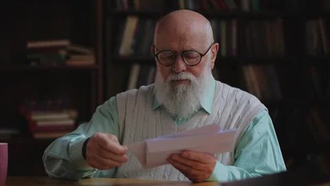 Male pensioner sorting postal mail at home, organizing letters and utility bills Stock Footage 320671326