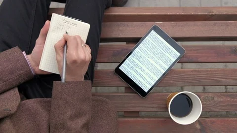 Male person writing notes, using portable computer and drinking coffee Video stock 88981433