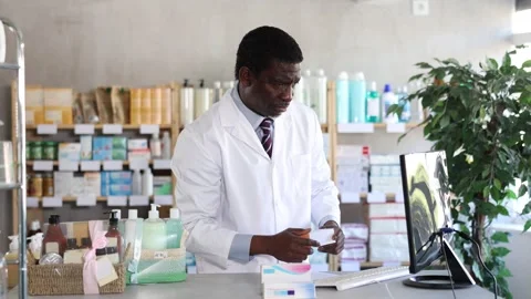 Male pharmacist working at computer in pharmacy Stock Footage 332635939