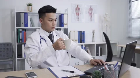 Male physician is taking a break drinking tea Stock Footage 150812261