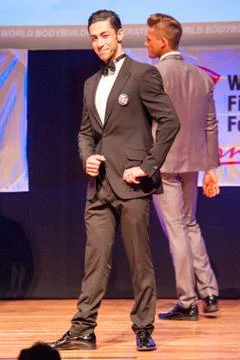 Male physique model shows his best in suit on stage Stock Photos