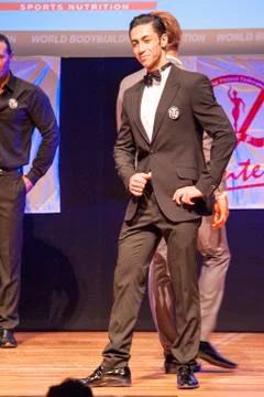Male physique model shows his best in suit on stage Stock Photos