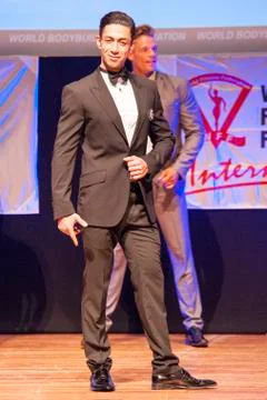 Male physique model shows his best in suit on stage Stock Photos