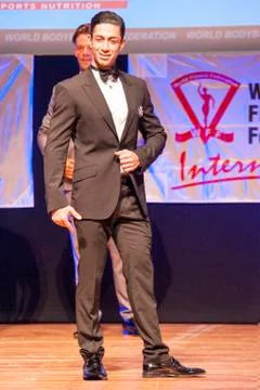 Male physique model shows his best in suit on stage Stock Photos