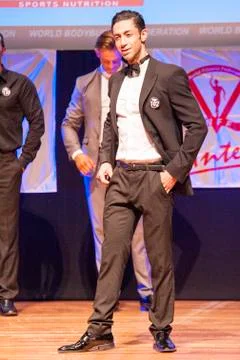 Male physique model shows his best in suit on stage Stock Photos