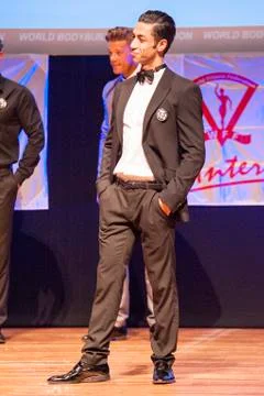 Male physique model shows his best in suit on stage Stock Photos