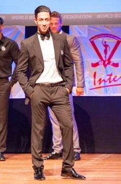 Male physique model shows his best in suit on stage Stock Photos
