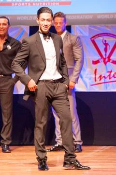 Male physique model shows his best in suit on stage Stock Photos