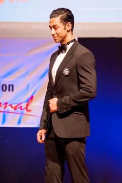 Male physique model shows his best in suit on stage Stock Photos