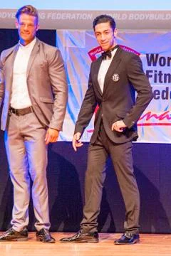 Male physique model shows his best in suit on stage Stock Photos