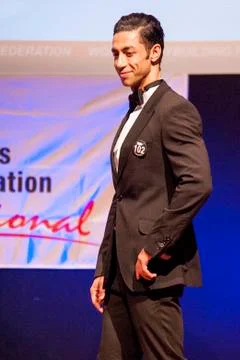 Male physique model shows his best in suit on stage Stock Photos