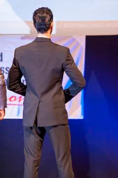 Male physique model shows his best in suit on stage Stock Photos