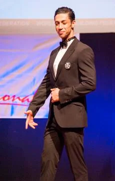 Male physique model shows his best in suit on stage Stock Photos
