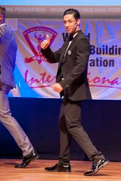 Male physique model shows his best in suit on stage Stock Photos