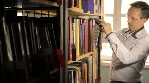 Male picking a book in a library Video stock 63139938