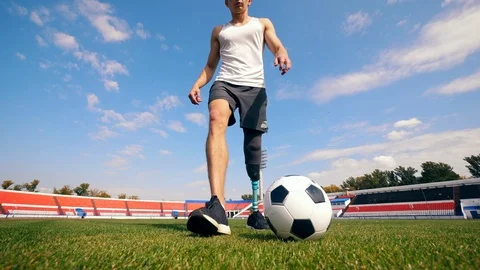 Male player with a bionic leg is practicing with a ball Stock Footage 116800539