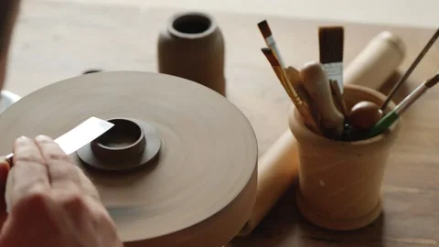 Male potter forms a lid for a clay teapot on a potter's wheel. craft work Stock Footage 145534580