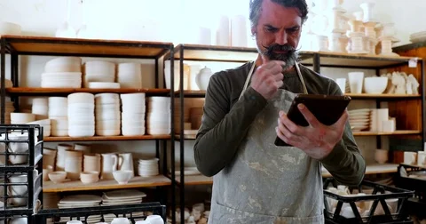 Male potter using digital tablet 4k Stock Footage 85322681