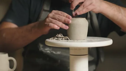 Male potter using tools to making ceramic clay cup in potter studio Video stock 143617101