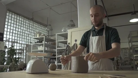 Male potter is working while standing at table in pottery workshop. Video stock 88412349