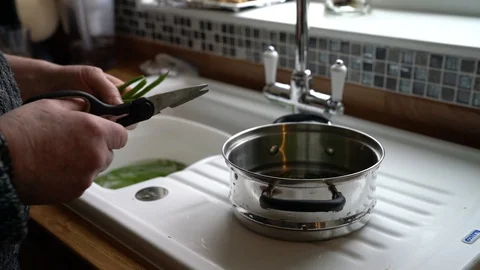 Male preparing green beans for steaming in home kitchen Stock Footage 86979957