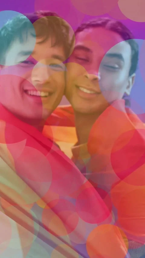 Male-presenting, non-binary partners reaching for rainbow fabric, wrapping for Stock Footage 331703030