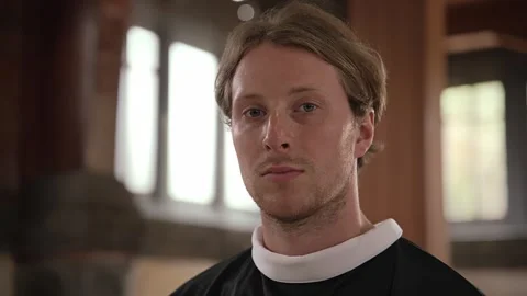 Male Priest Looking at Camera While Standing Inside Church Stock Footage 257410153
