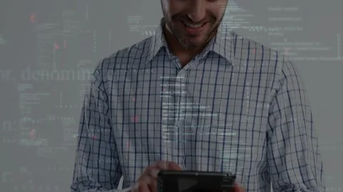 Male pro tapping foldable tablet in grey studio, showing code overlays while Stock Footage 334033587