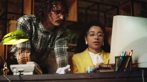 Male programmer from 90s helping puzzled secretary fix program in retro office Stock Footage 321072105