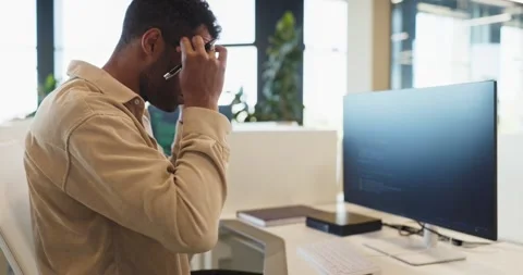Male programmer adjusting glasses while coding at computer in office workstation Stock Footage 340134371