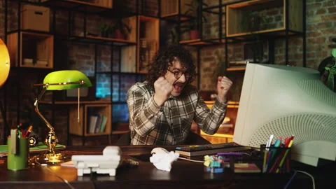 Male programmer celebrating successful computer program launch in retro office Stock Footage 315456003