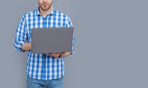 Male programmer crop view programming on laptop computer studio isolated on grey 库存照片