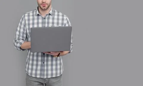 Male programmer crop view programming on laptop computer studio isolated on grey Stockfoto's