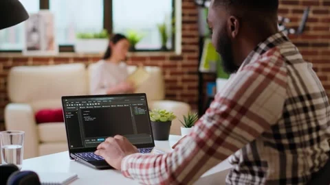 Male programmer developing an app on his laptop and working remotely Video stock 319716693