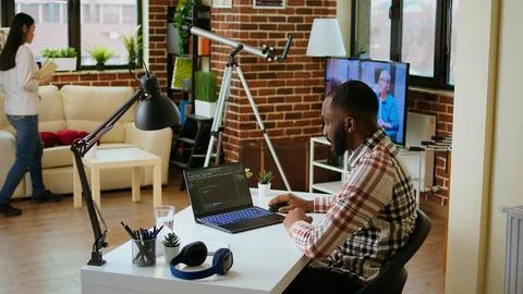 Male programmer developing an app on his laptop and working remotely Stock Photos