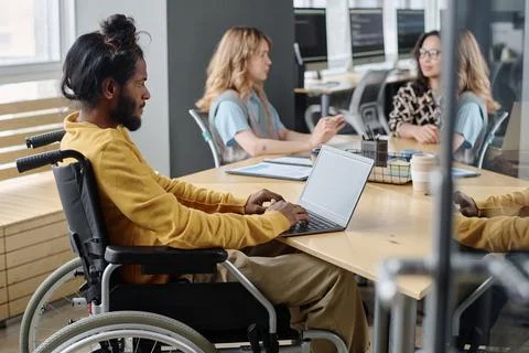 Male Programmer with Disability Working on His Portable Computer in Office Stockfoto's