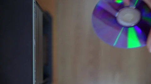 A male programmer inserts a CD-DVD from a computer drive. View from above Stock Footage 125814018