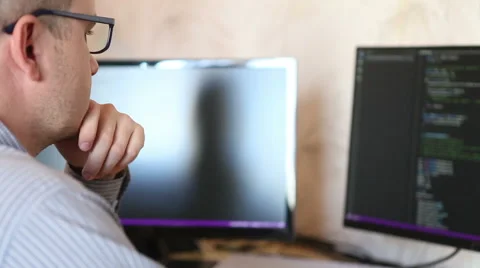 Male programmer looking for errors in the program code. Stock Footage 64830385
