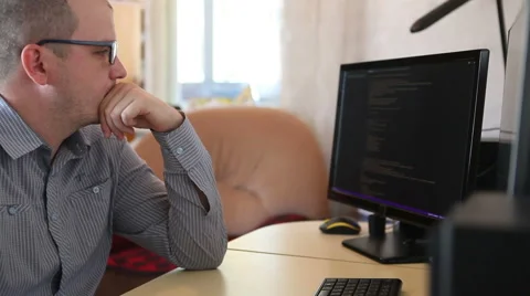 Male programmer looking for errors in the program code. Stock Footage 64830408