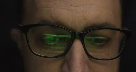 A male programmer sits in glasses in front of a monitor and creates a progr.. Stock Footage 299424658